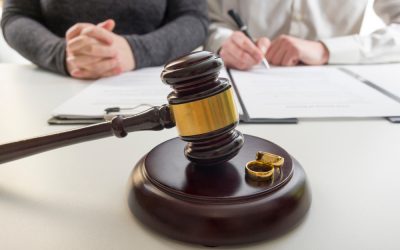 Hands of wife, husband signing decree of divorce, dissolution, canceling marriage, legal separation documents, filing divorce papers or premarital agreement prepared by lawyer. Wedding ring